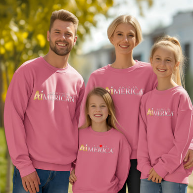 a family of three wearing pink sweatshirts